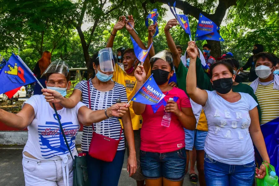 Supporters welcome Philippine boxing icon and Senator Manny Pacquiao as he arrives on a bus to file his certificate of candidacy for the Philippine presidency in Manila on 1 October 2021. (Maria Tan/AFP)