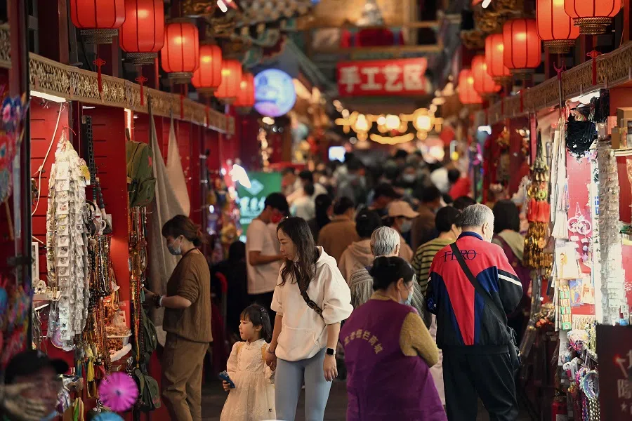 People walk at an alley on Qianmen street in Beijing, China, on 2 October 2022. (Noel Celis/AFP)