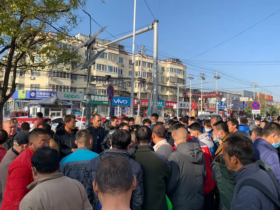 Rural migrant workers gather around a recruiter at Beijing’s Tongzhou district looking for work. Rural migrants arriving in Beijing often head to the Majuqiao labour market where they can find short-term jobs that often pay by the day. (SPH Media)