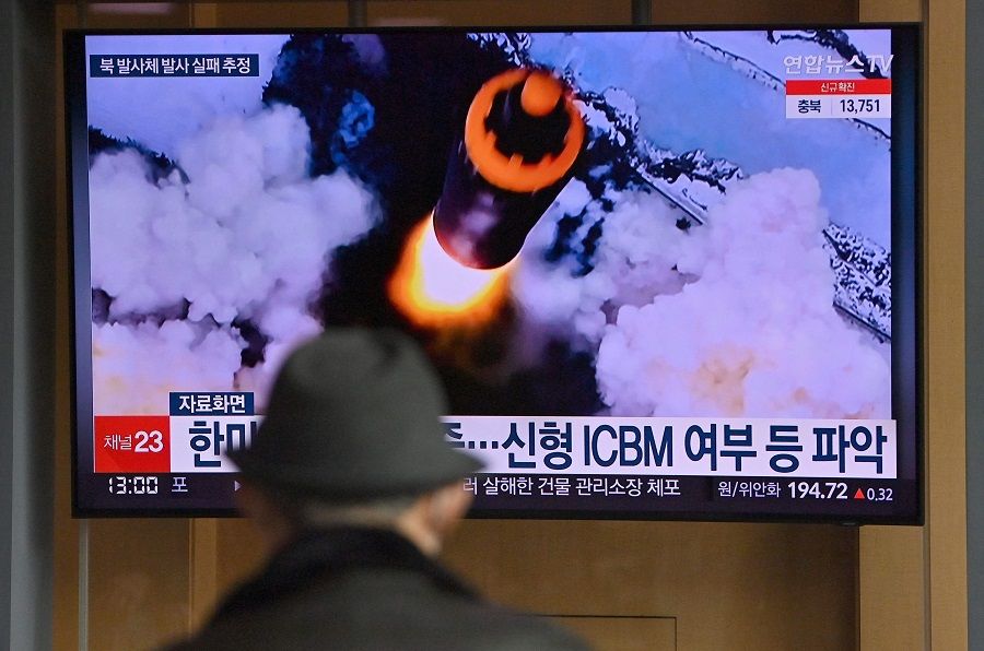 People watch a television screen showing a news broadcast with file footage of a North Korean missile test, at a railway station in Seoul, South Korea, on 16 March 2022. (Jung Yeon-je/AFP)