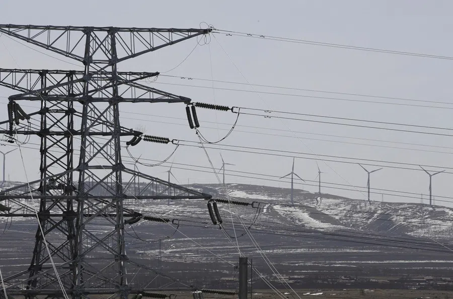 Power lines and wind turbines are pictured at a wind and solar energy storage and transmission power station of State Grid Corporation of China, in Zhangjiakou of Hebei province, China, on 18 March 2016.