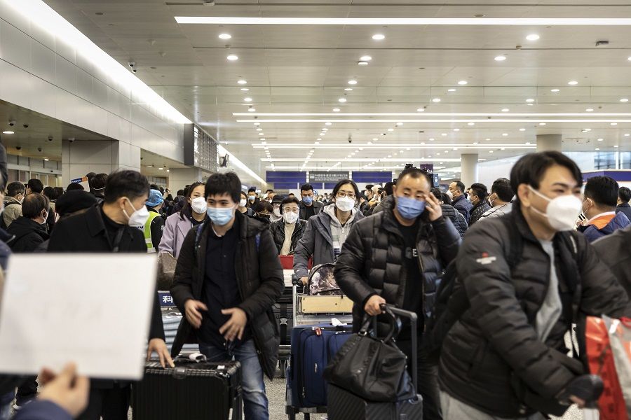 Passengers walk past greeters in the arrival hall for international flights at Shanghai Pudong International Airport in Shanghai, China, on 8 January 2023. (Qilai Shen/Bloomberg)