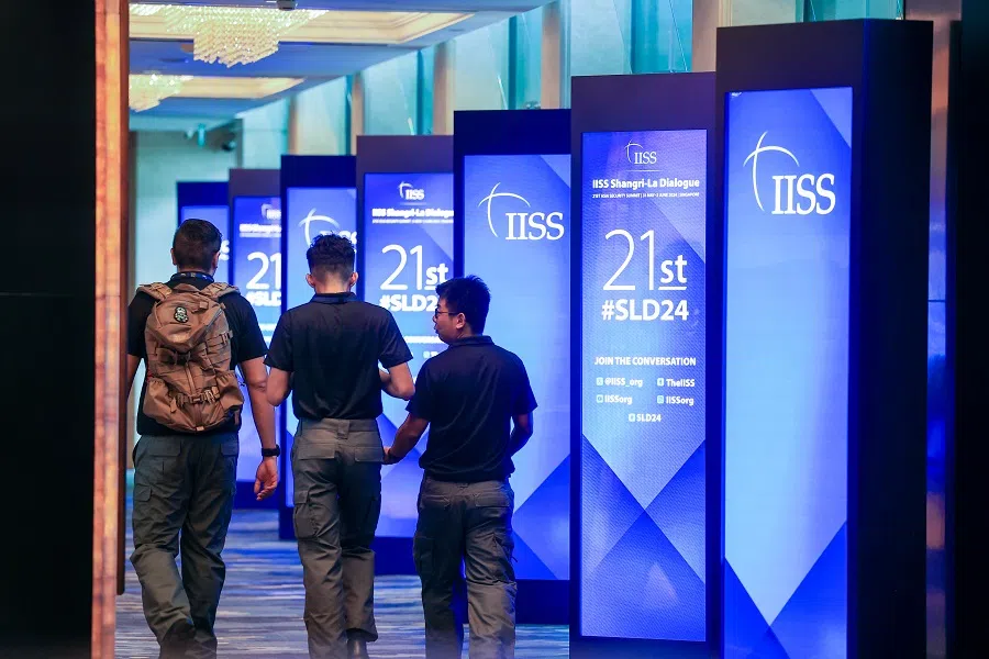 Guests seen walking by screens for the Shangri-La Dialogue in 2024. (SPH Media)