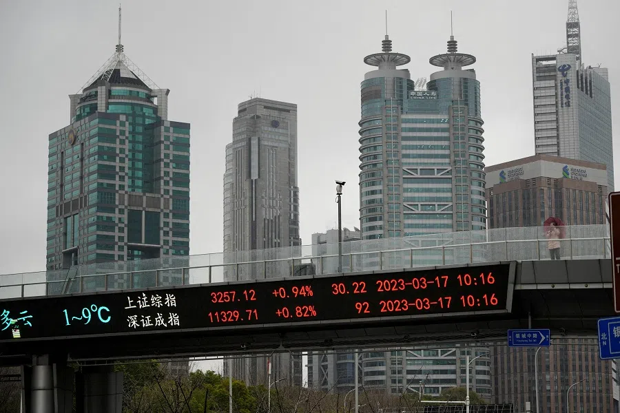 An electronic board shows Shanghai and Shenzhen stock indices at the Lujiazui financial district in Shanghai, China, 17 March 2023. (Aly Song/Reuters)