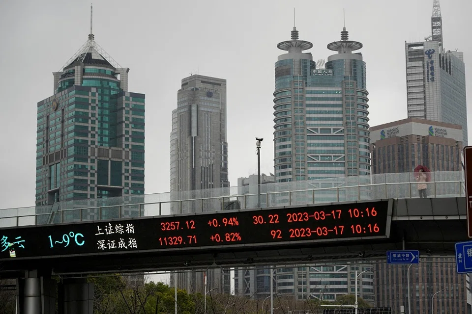 An electronic board shows Shanghai and Shenzhen stock indices at the Lujiazui financial district in Shanghai, China, 17 March 2023. (Aly Song/Reuters)