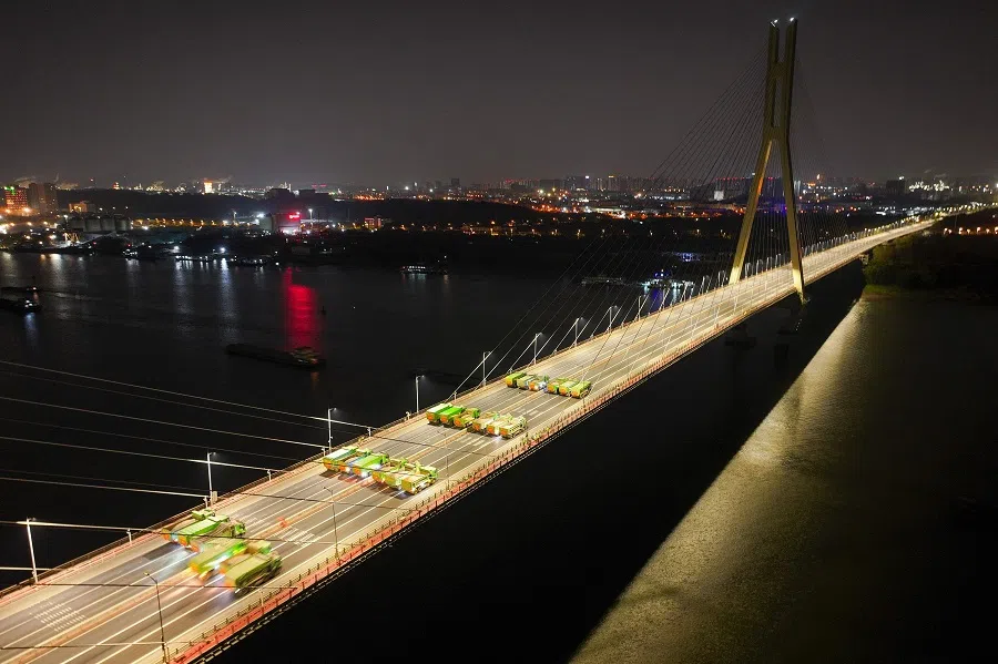 Loaded trucks drive on the Baguazhou Yangtze river bridge for a safety test inspection in Nanjing, Jiangsu province, China, on 18 December 2024. (AFP)