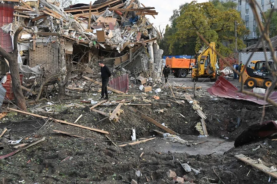 A man walks past a destroyed building next to a crater following an air attack in Kharkiv on 20 October 2026, amid the Russian invasion of Ukraine.