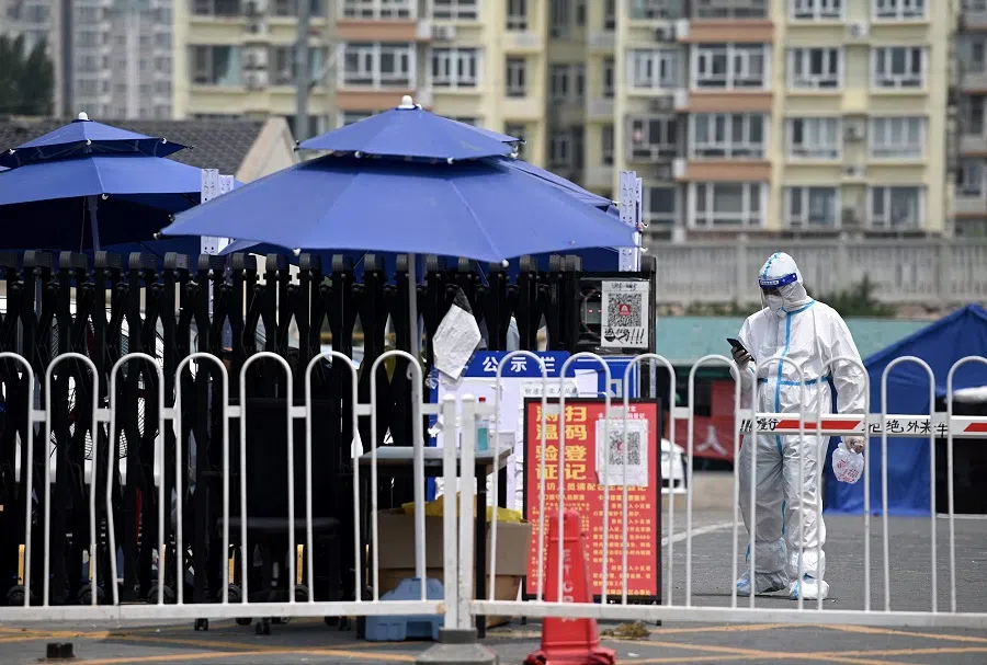 A security guard wearing personal protective equipment (PPE) stands at an entrance to a residential area under lockdown due to Covid-19 restrictions in Beijing, China, on 20 June 2022. (Noel Celis/AFP)