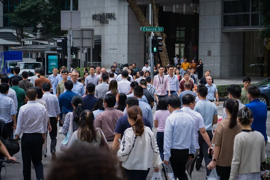 Pedestrians cross a road in Singapore, 31 August 2023. (Nicky Loh/Bloomberg)