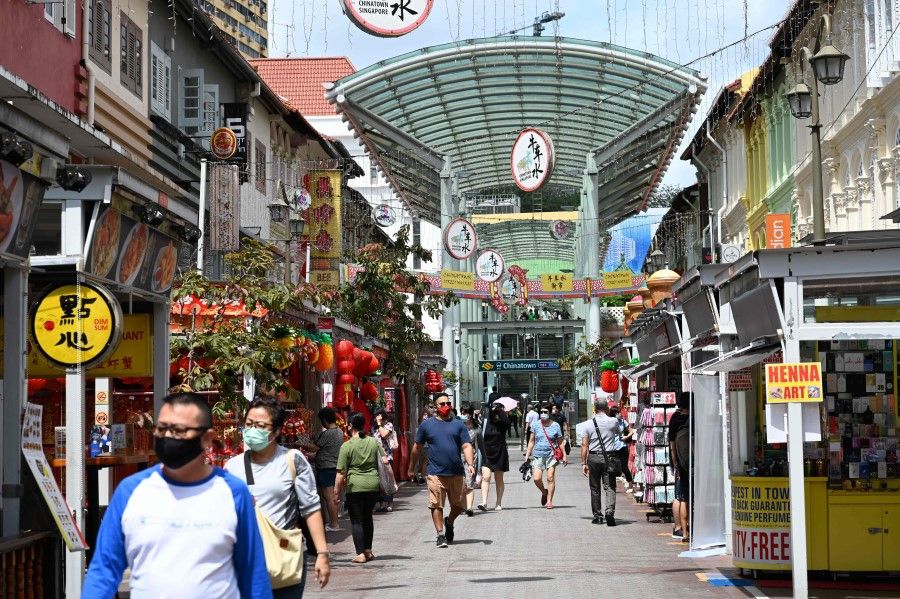 People walk past shops in the Chinatown area of Singapore on 25 January 2021. (Roslan Rahman/AFP)