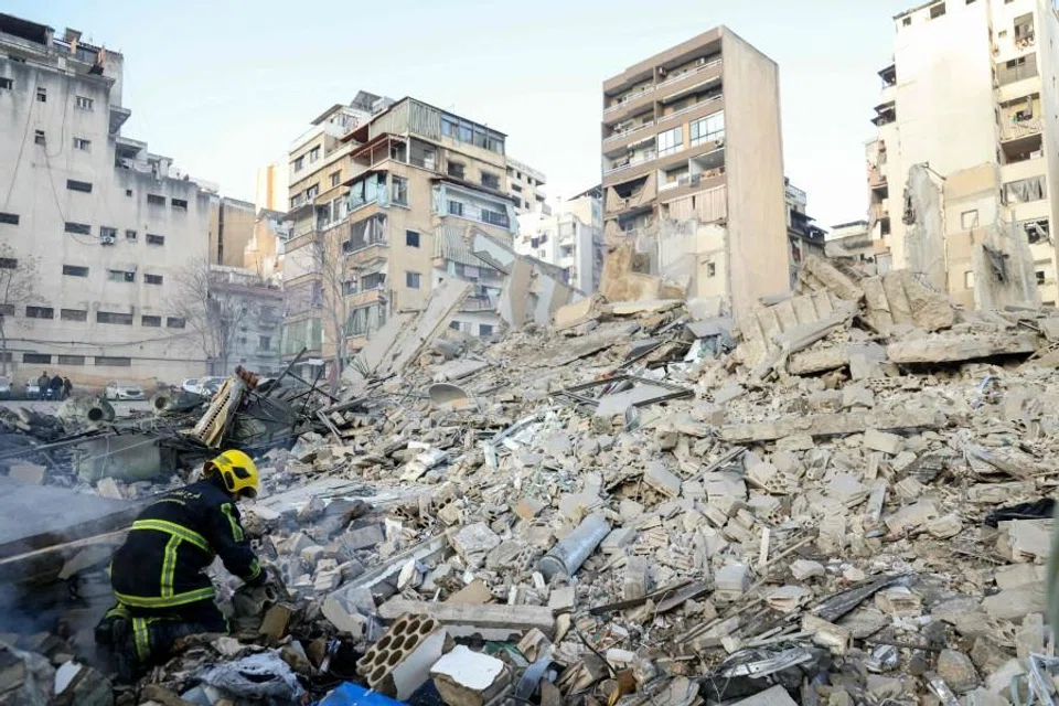 A firefighter looks at debris at the site of an Israeli airstrike in Beirut’s Bashoura neighborhood on 18 March 2026. (Ibrahim Amro/AFP)