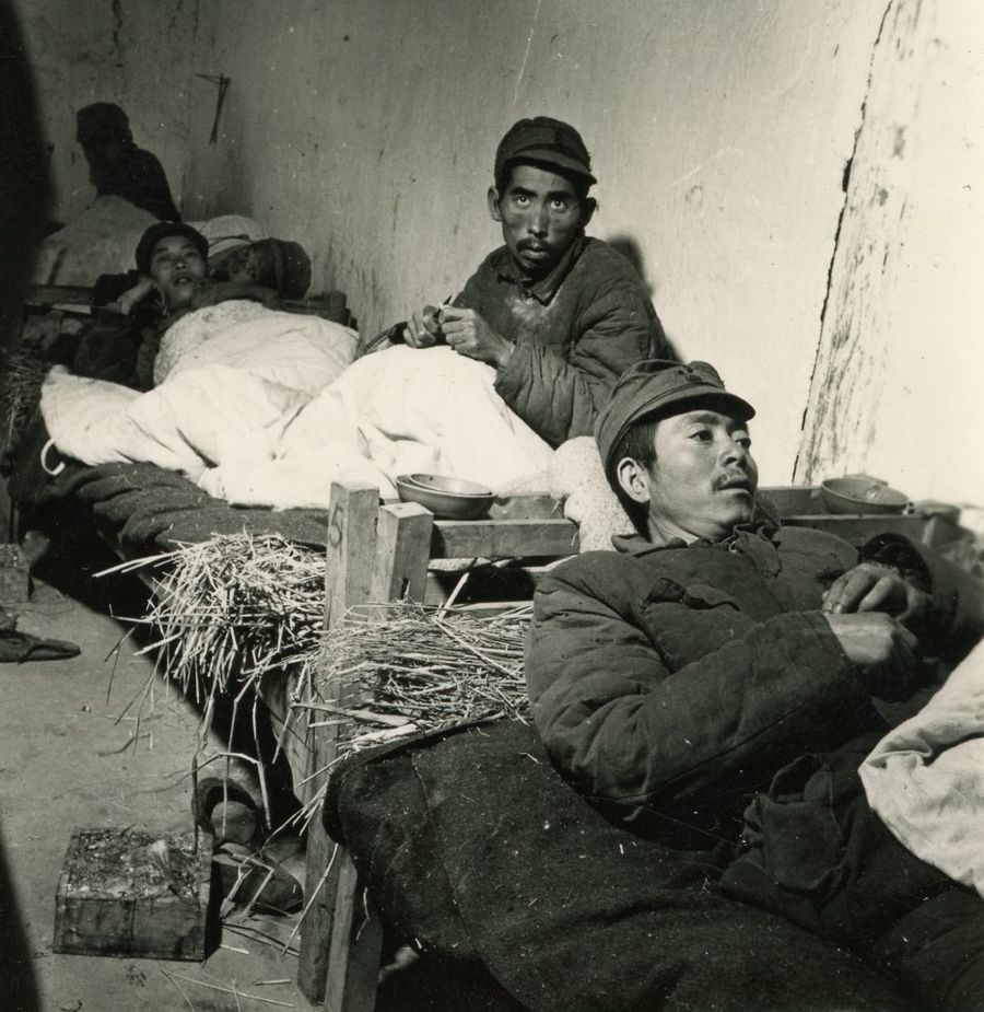 Chinese soldiers resting on bug-infested straw bedding.