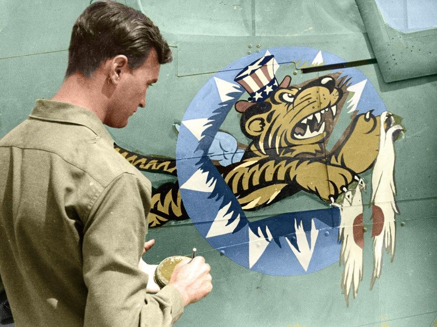 A US volunteer pilot drawing the logo of the Flying Tigers on an aircraft, 1943.