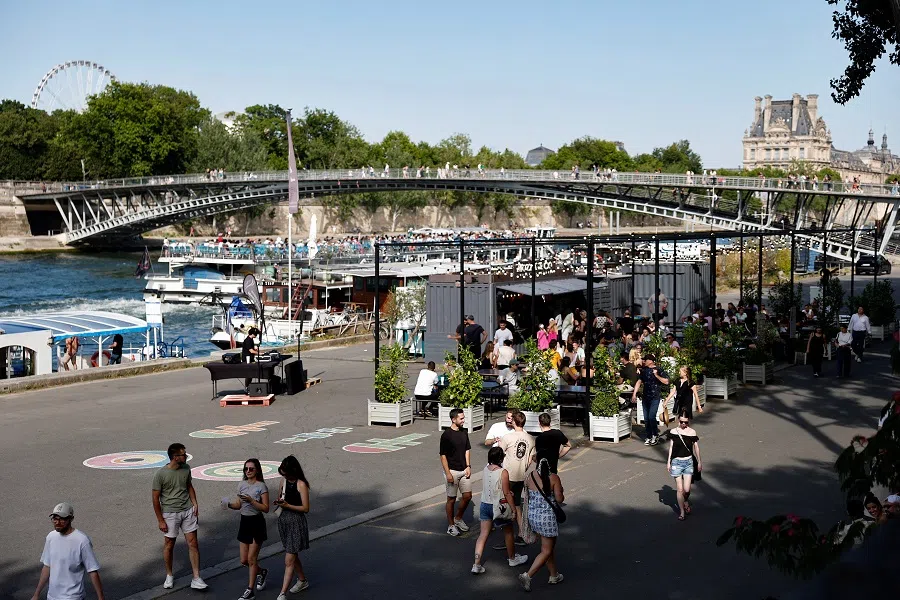 People walk on the bank of the Seine river in Paris, France, on 21 June 2025. (Benoit Tessier/Reuters)