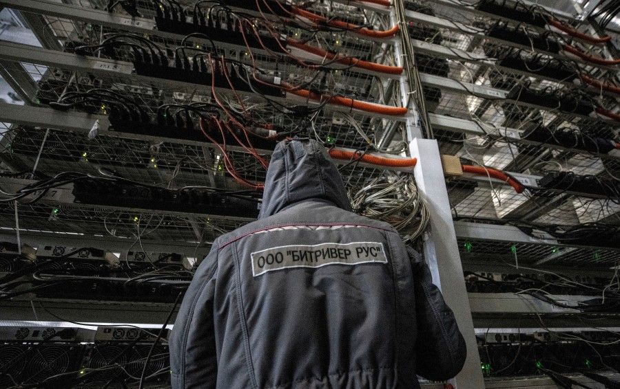 An employee works at the data centre of BitRiver company providing services for cryptocurrency mining in the city of Bratsk in Irkutsk Region, Russia, 2 March 2021.(Maxim Shemetov/Reuters)