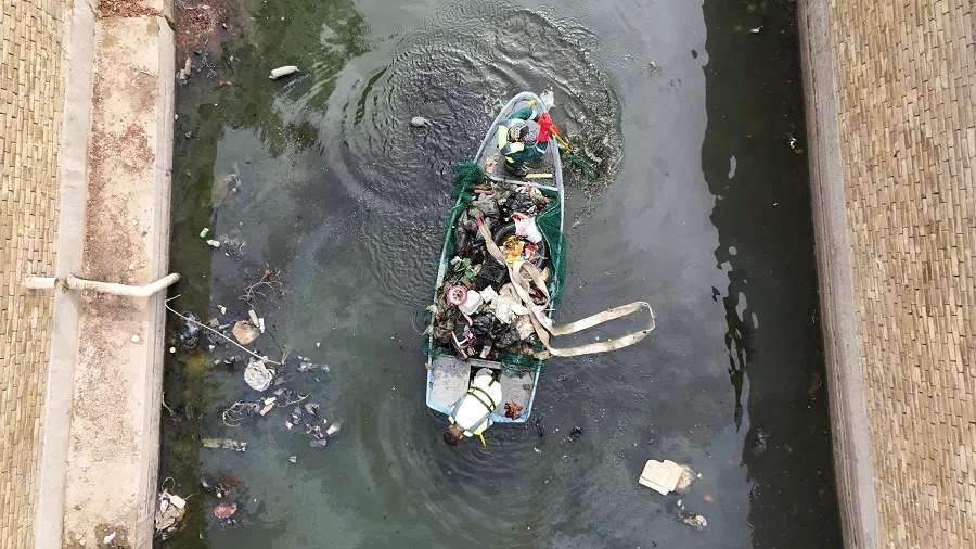 A drone view shows workers clean a polluted section of the Al-Ashar River in Basra, Iraq, on 30 April 2025.