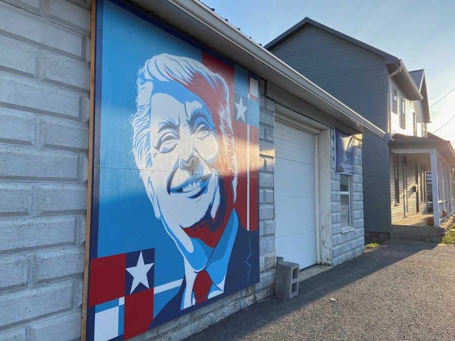A mural of a smiling U.S. President Donald Trump is seen on the side of a business on Election Day in McConnellsburg, Pennsylvania 3 November 2020. (Nathan Layne/REUTERS)