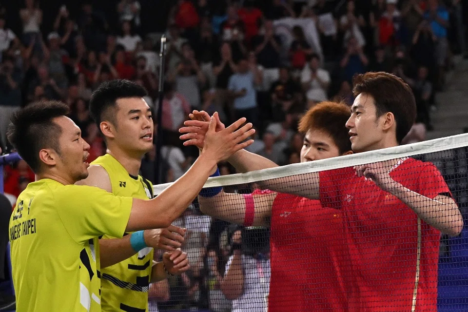People’s Republic of China’s Wang Chang and Liang Weikeng congratulate Chinese Taipei’s Wang Chi-lin and Lee Yang after the men’s doubles badminton final match during the Paris 2024 Olympic Games at Porte de la Chapelle Arena in Paris, France, on 4 August 2024. (Arun Sankar/AFP)