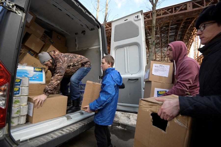 Activists of the nationalist Liberal-Democratic Party of Russia (LDPR) load food aid for evacuees from the self-proclaimed Donetsk and Lugansk People's Republics temporary settled in Russia's Rostov region into a van during a gathering in support of Russian military action in Ukraine, in Moscow on 14 March 2022. (AFP)