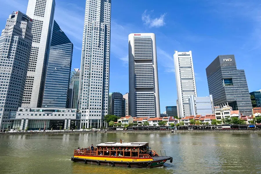 Visitors tour the river by boat alongside high-rise office buildings in Singapore’s financial district on 6 May 2025.