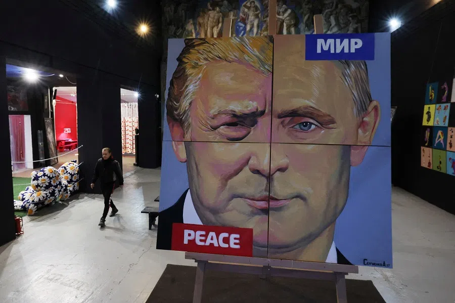 Artist Alexei Sergienko walks towards his painting “Peace to the World” showing a combination of faces of Russian President Vladimir Putin and US President Donald Trump, at the Sergienko gallery in Saint Petersburg, Russia, on 17 March 2025.