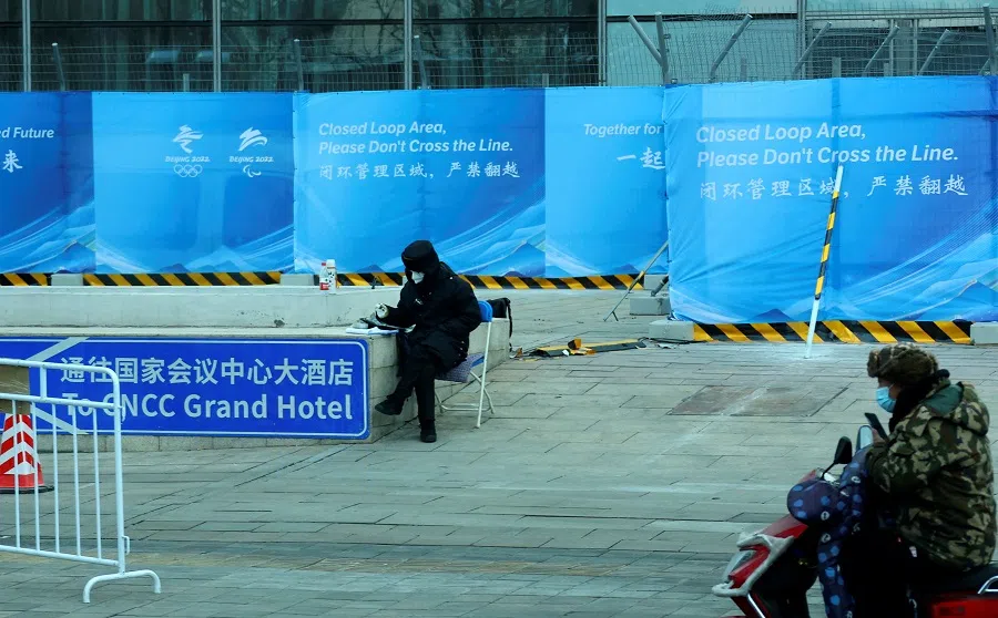 A security personnel guards a fence at an entrance of a hotel inside a closed loop area designed to prevent the spread of the Covid-19 coronavirus ahead the Beijing 2022 Winter Olympics in Beijing, China, 26 January 2022. (Fabrizio Bensch/Reuters)