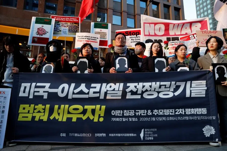 Participants hold banners and mock funeral portraits during a protest to condemn the US and Israeli attacks on Iran and commemorate students killed in a strike on a girls’ primary school in Minab in southern Iran on 28 February 2026, in front of the Israeli embassy in Seoul, South Korea, on 12 March 2026. (Kim Soo-hyeon/Reuters)