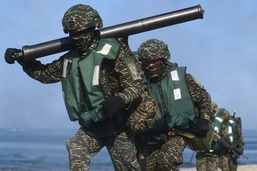 Soldiers exiting from AAV7 amphibious assault vehicle run to position during an amphibious landing drill as part of the Han Kuang military exercise in Pingtung, Taiwan, 28 July 2022. (Ann Wang/Reuters)