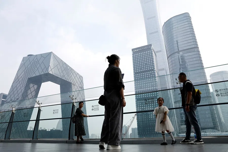 People stand at a shopping mall near the CCTV headquarters and China Zun skyscraper, in Beijing's central business district, China, on 7 September 2023. (Tingshu Wang/Reuters)