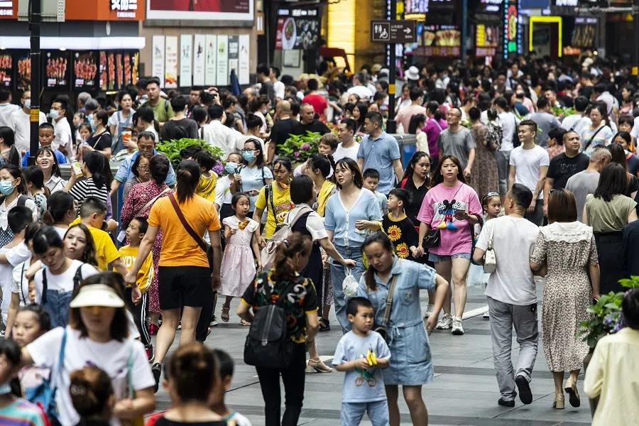 People walk along a road in a shopping area in Chongqing, China on 1 June 2021. (Qilai Shen/Bloomberg)