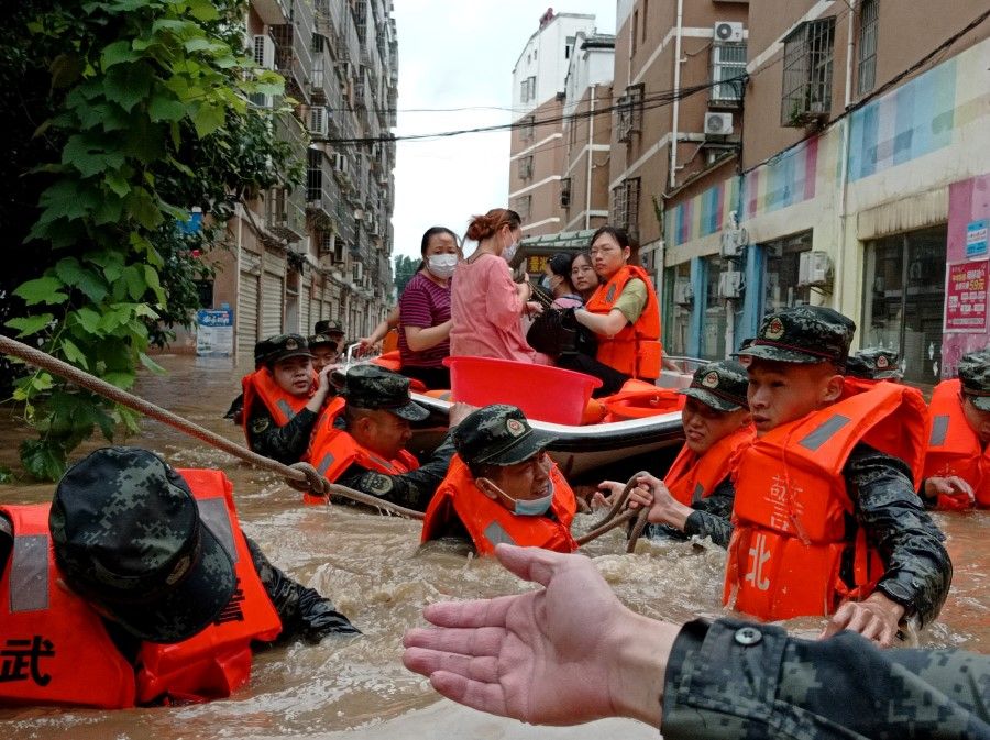 Paramilitary police officers evacuate residents stranded by floodwaters with a boat following heavy rainfall in Hedian town of Suizhou, Hubei province, China, 12 August 2021. (cnsphoto via Reuters)