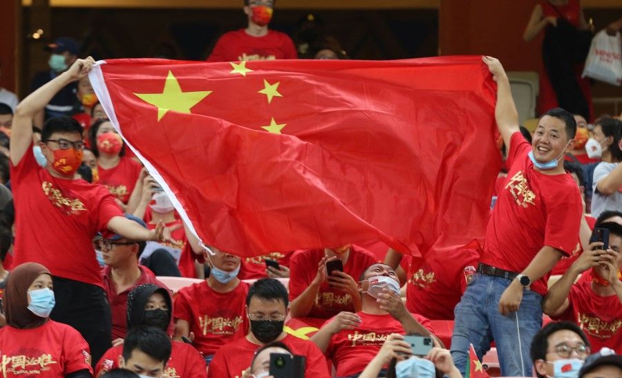 China supporters wave the national flag during the 2022 Qatar World Cup Asian Qualifiers football match between Saudi Arabia and China, at the King Abdullah Sport City Stadium in Jeddah, Saudi Arabia, on 12 October 2021. (AFP)