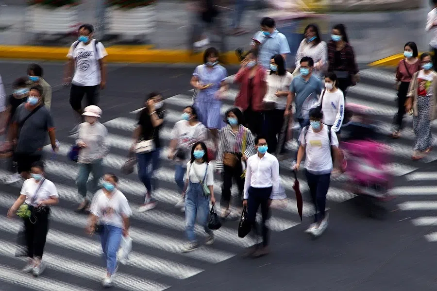 People wearing face masks walk on a street in Shanghai, China, 16 July 2020. (Aly Song/Reuters)