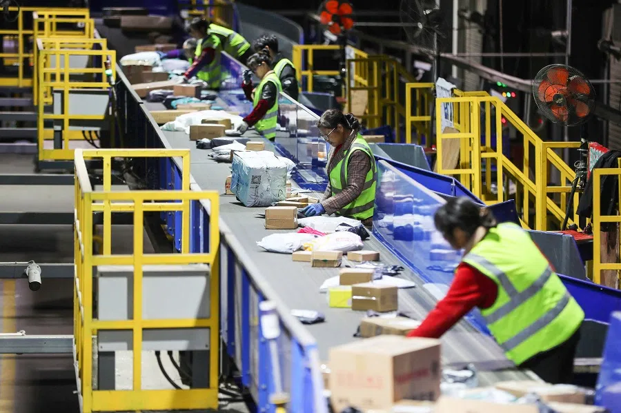 This photo taken on 12 November 2023 shows workers sorting packages for delivery after the Singles' Day shopping festival at a logistics centre in Hengyang, Hunan province, China. (AFP)