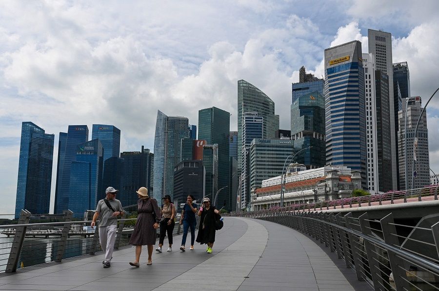 People walk over Jubilee Bridge at Marina Bay waterfront in Singapore on 17 November 2023. (Roslan Rahman/AFP)