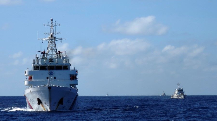 Chinese coastguard ships give chase to Vietnamese coastguard vessels (not pictured) after they came within 10 nautical miles of the Haiyang Shiyou 981, known in Vietnam as HD-981, oil rig in the South China Sea, 15 July 2014. (Martin Petty/Reuters)