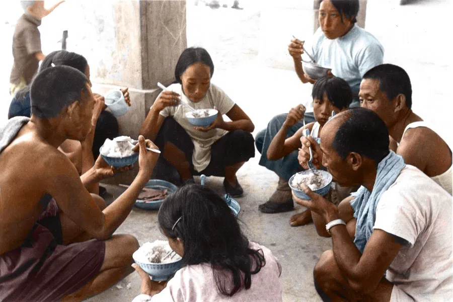 In 1953, about 30,000 KMT soldiers and their families who had stayed behind in Vietnam came to Taiwan in batches. The photo shows them squatting to have their meal in their temporary lodgings on arrival in Taiwan.