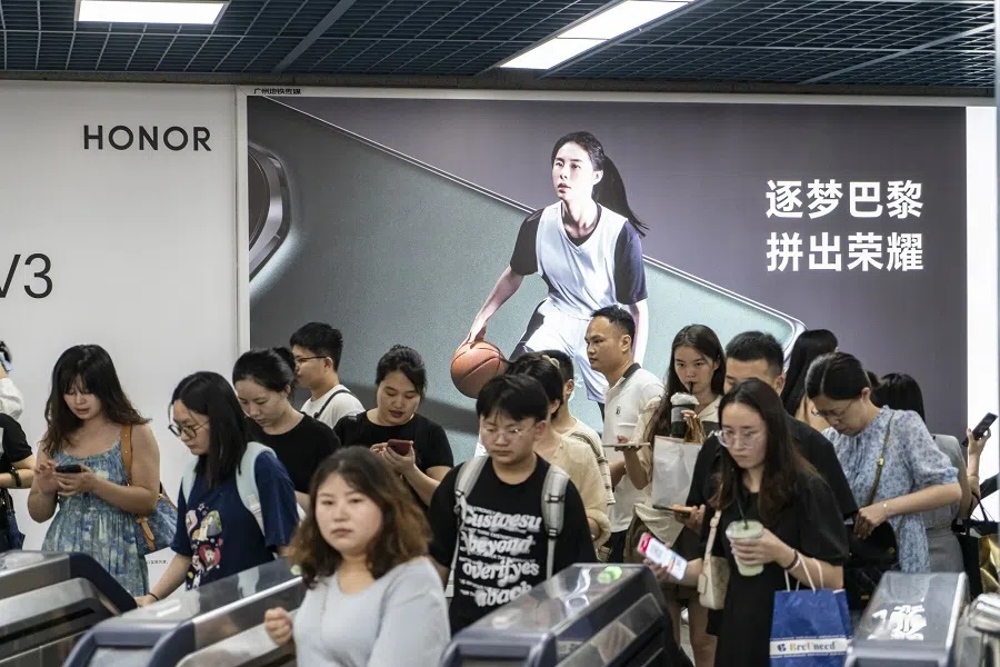 Passengers pass through turnstiles at a subway station in Guangzhou, China, on 30 July 2024. (Qilai Shen/Bloomberg)