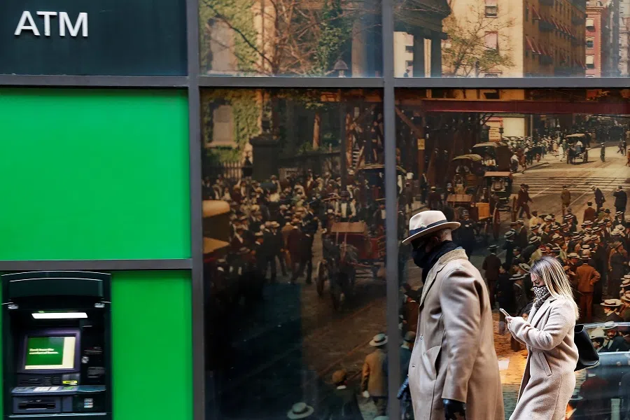 People wearing protective face masks walk in the financial district of New York, US, 19 November 2020. (Shannon Stapleton/Reuters)