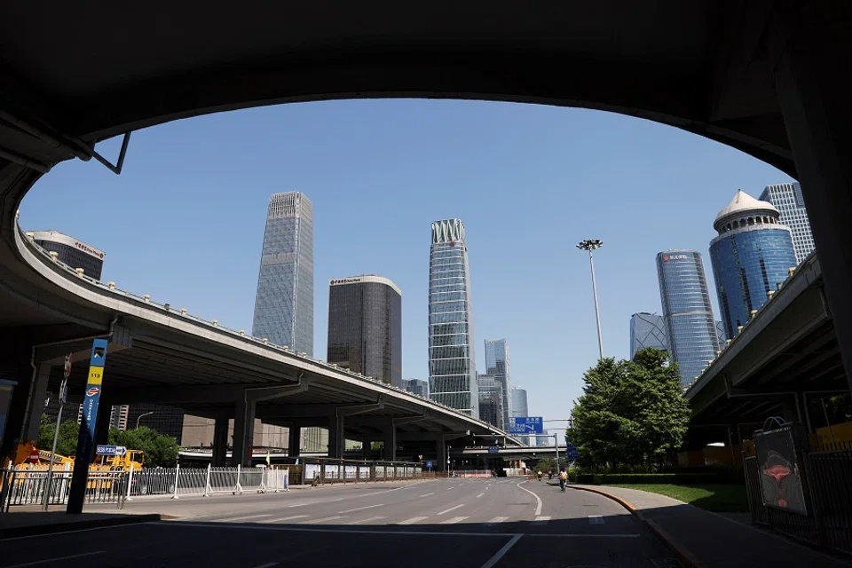 People cycle on a road at the central business district in Beijing, China, 16 May 2022. (Tingshu Wang/Reuters)