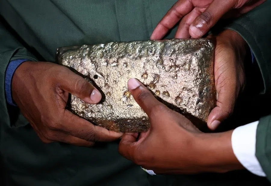 Visitors hold a rough gold bar inside a processing room at Sibanye Stillwater's Ezulwini Processing plant near Westonaria, west of Johannesburg, South Africa, 17 March 2026.
