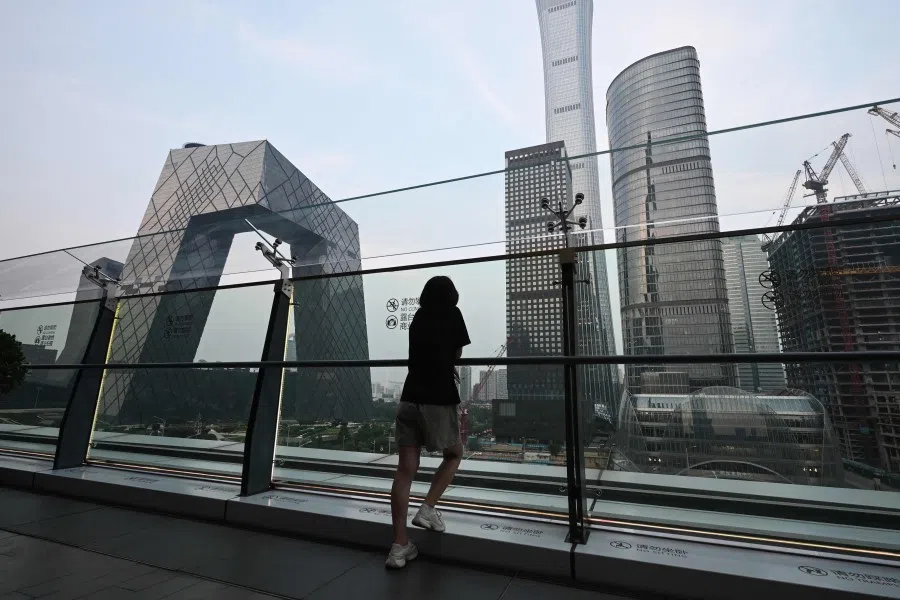 A woman looks at buildings on the the skyline from a viewing platform in a mall in Beijing’s central business district on 11 July 2024.