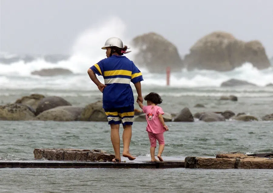 A Taiwanese mother and child walk at the seafront in the northern port of Keelung on 22 August 2000.