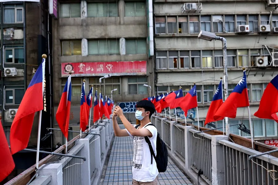 A man takes photos on an overpass decorated with Taiwan flags in Taipei, Taiwan, 7 October 2021. (Ann Wang/Reuters)