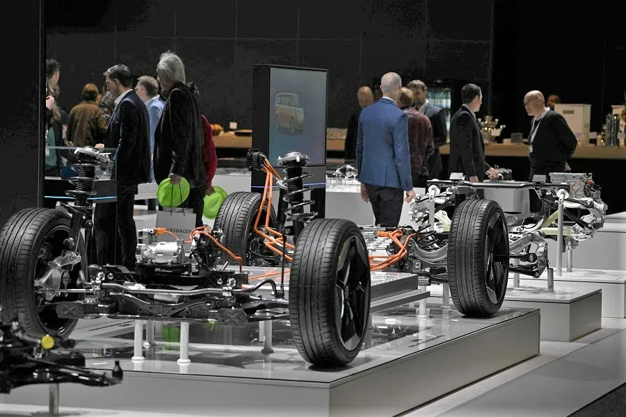 People walk around automotive equipment before the annual general meeting of German carmaker Volkswagen in Berlin, Germany, on 10 May 2023. (Tobias Schwarz/AFP)
