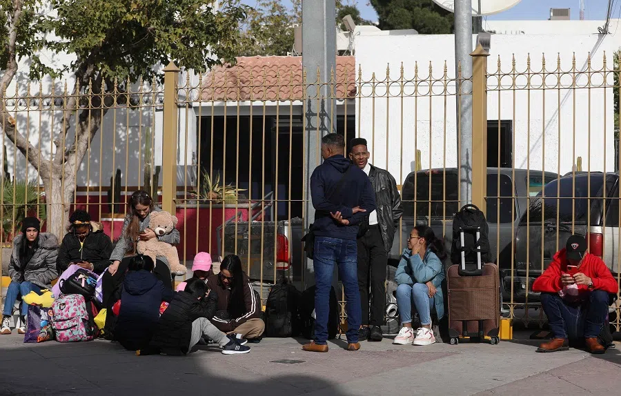 A group of migrants seeking asylum in the US through the CBP One digital application wait in line near the Paso del Norte international bridge in Ciudad Juarez, Chihuahua State, Mexico, on 28 November 2024. (Herika Martinez/AFP)