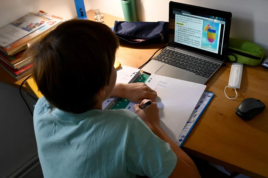 In this file photo taken on 6 April 2021, a child does his homework in Marseille, France. (Nicolas Tucat/AFP)