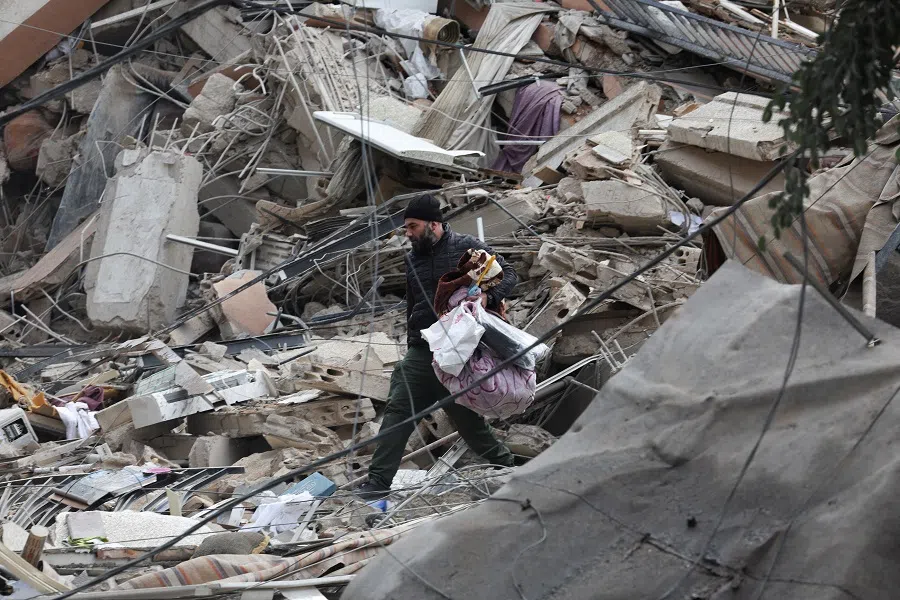 A man walks on debris with belongings in Beirut’s southern suburbs, after a ceasefire between Israel and Iran-backed group Hezbollah took effect, in Lebanon, on 27 November 2024. (Mohamed Azakir/Reuters)