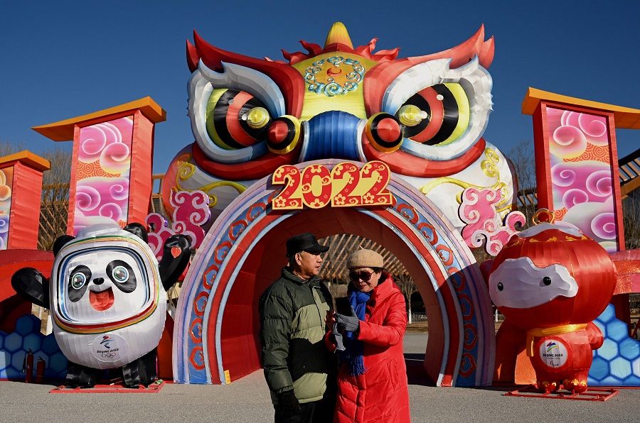 A couple stands in front of mascots of the 2022 Beijing Winter Olympic and Paralympic Games, at the Beijing World Horticultural Exposition in Yanqing, on the outskirts of Beijing, China, on 13 January 2022. (Noel Celis/AFP)