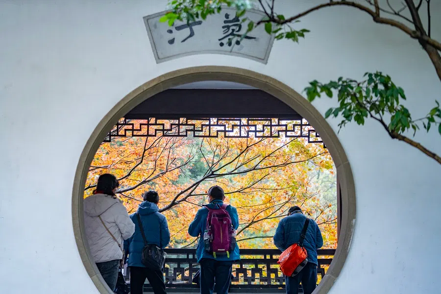 People tour Quyuan Fenghe (Breeze-Rustled Lotus In Quyuan Garden), one of the top ten sceneries of West Lake, in Hangzhou, Zhejiang province, China, on 11 December 2024.